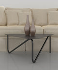 Triangular modern metal coffee table with sculptural legs in living room طاولة قهوة معدنية عصرية بشكل مثلث وأرجل نحتية في غرفة المعيشة